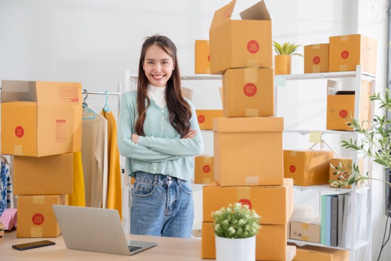 Portrait Asian female SME retail store owner in her home office with parcel box background